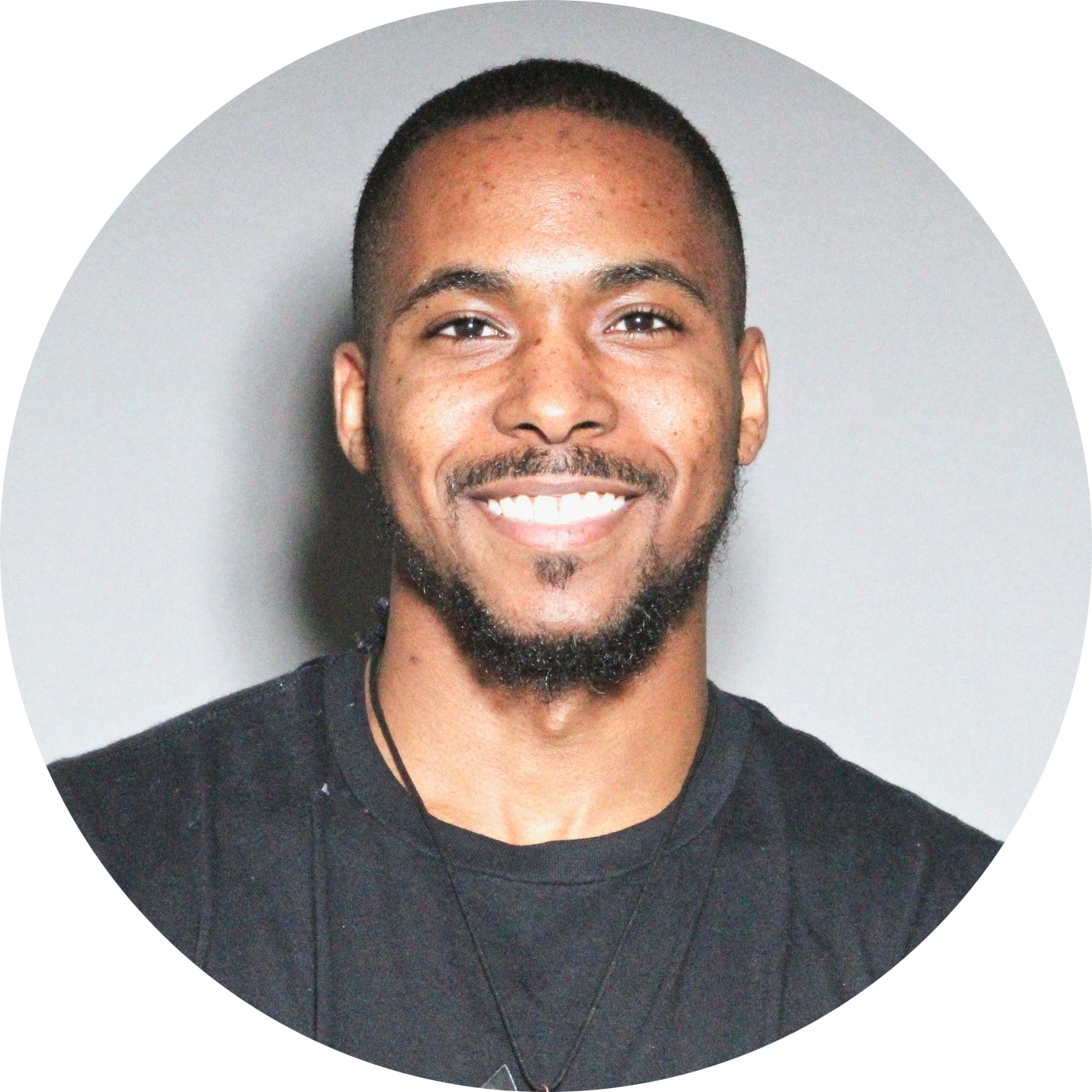 Darius Clair, Program Manager for Techstars DC & Techstars Baltimore. Darius is a young Black man, smiling broadly at the camera, with a light goatee, wearing a dark grey tshirt.